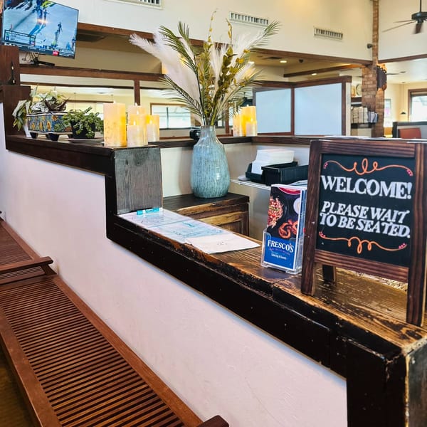 Fresco's Cocina Mexicana's waiting area with a "Please Wait To Be Seated" sign and decor.