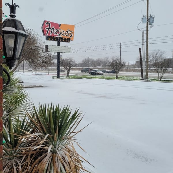 Fresco's Cocina Mexicana sign visible above a snow-covered parking lot and street with cars.